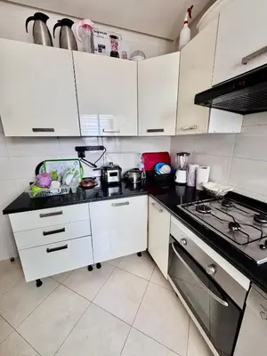 a kitchen with white cabinets and a stove at Wifak beach rental in Temara