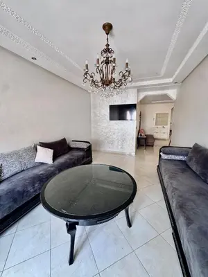 a living room with a couch and a glass table at Wifak beach rental in Temara