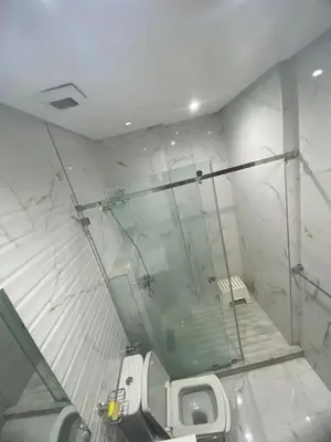 a bathroom with a toilet and a glass shower at The White House in Casablanca