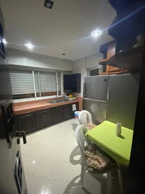 a kitchen with a green table and a refrigerator at The White House in Casablanca