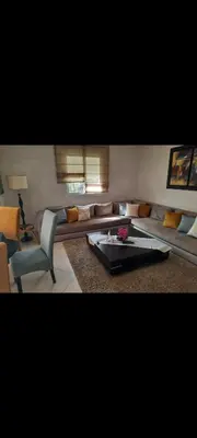 a living room with a couch and a table at Bahia golf beach pavillon in Bouznika