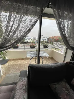 a living room with a couch and a large window at Magnifique appartement à louer in Mohammedia