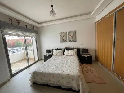 a bedroom with a large bed and a large window at Magnifique appartement à louer in Mohammedia
