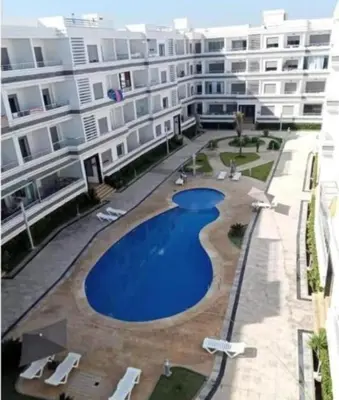 a large apartment building with a large swimming pool at Magnifique appartement à louer in Mohammedia
