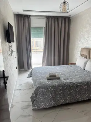 a bedroom with a large bed and a window at Elégant appartement 2 Bedroom près de la plage Rabat in Rabat