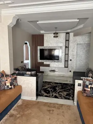 a living room with couches and a flat screen tv at Elégant appartement 2 Bedroom près de la plage Rabat in Rabat