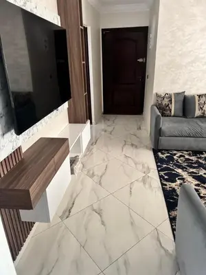 a living room with marble flooring and a television at Elégant appartement 2 Bedroom près de la plage Rabat in Rabat