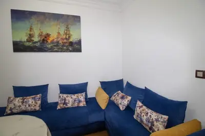 a blue couch with pillows and a painting on the wall at good Nice appartement in Casablanca
