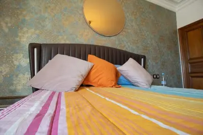 a bed with two pillows and a mirror on the wall at good Nice appartement in Casablanca