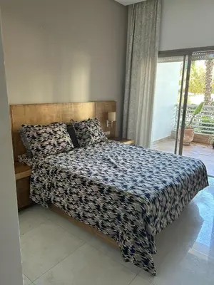 a bedroom with a bed with a black and white comforter at Costa Beach 2 in Bouznika