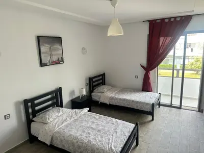 two beds in a room with a window at Seaside apartment in El Mansouria in Mansouria
