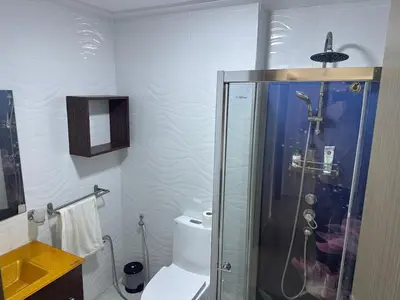 a bathroom with a toilet and a glass shower at Seaside apartment in El Mansouria in Mansouria