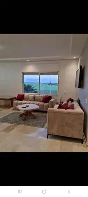 a living room with two couches and a large window at Appartement de luxe avec piscine à Mansouria in Mansouria