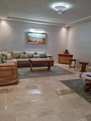 a living room with a couch and a table at Appartement de luxe avec piscine à Mansouria in Mansouria
