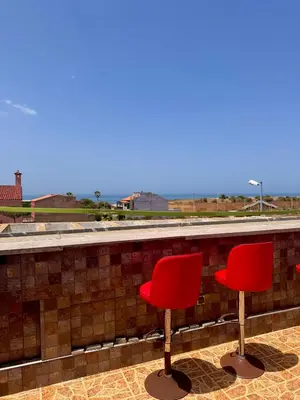 two red chairs sitting on top of a roof at Villa Rina in Sidi Rahal