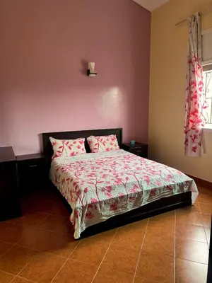 a bedroom with a bed with pink walls at Villa Rina in Sidi Rahal