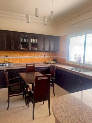 a kitchen with a table and chairs and a sink at Villa Rina in Sidi Rahal