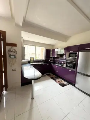 a kitchen with purple cabinets and a chair in it at Coastal serenity oasis in El Jadida