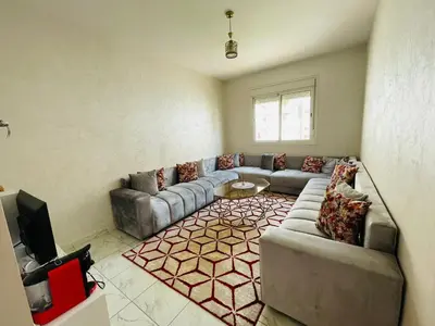 a living room with a couch and a tv at Appartement cosy avec vue jardin à Casablanca ! in Casablanca
