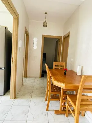 a kitchen and dining room with a wooden table and chairs at Appartement cosy avec vue jardin à Casablanca ! in Casablanca
