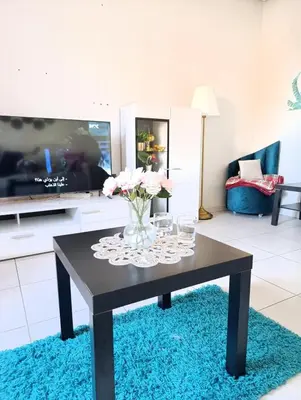 a living room with a table with a vase of flowers at Logement tout confort, équipé ! in Casablanca