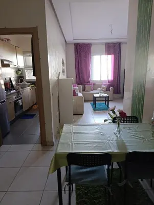 a kitchen and living room with a table and a table and chairs at Logement tout confort, équipé ! in Casablanca