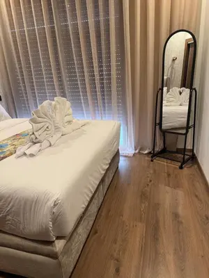 a bedroom with a white bed and a mirror at Beautiful apartment with a terrace in Casablanca