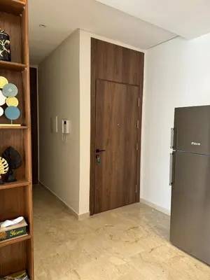 a kitchen with a wooden door and a refrigerator at Beautiful apartment with a terrace in Casablanca
