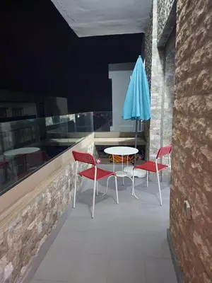 a patio with two chairs and a table and an umbrella at Malaga el Mansouria valence in Casablanca