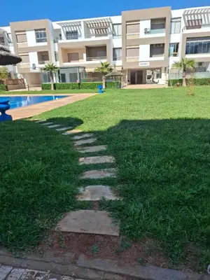 a walkway in the grass in front of a building at Malaga el Mansouria valence in Casablanca