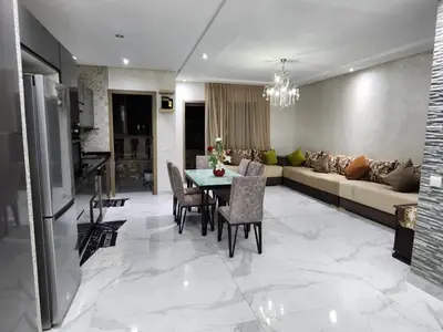 a living room with a table and a couch at Malaga el Mansouria valence in Casablanca