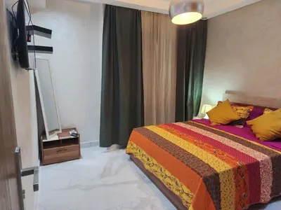 a bedroom with a bed with a colorful blanket at Malaga el Mansouria valence in Casablanca