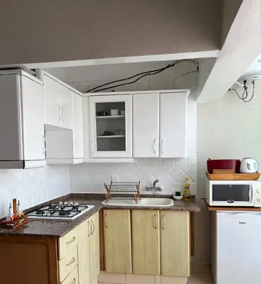 a kitchen with white cabinets and a stove top oven at Un studio meublé agréable à Casablanca in Casablanca