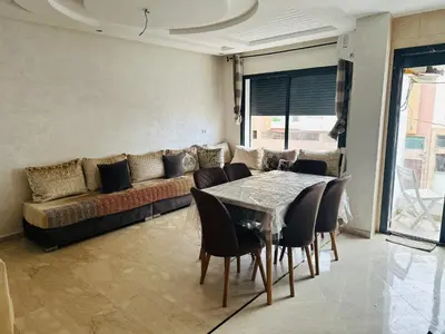 a living room with a couch and a table and chairs at Appartement vu sur mer in Pont Blondin