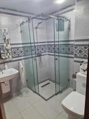 a bathroom with a shower and a toilet and a sink at الشروق 2 in Mansouria