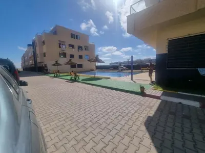 a building with a pool and a person standing next to a building at الشروق 2 in Mansouria