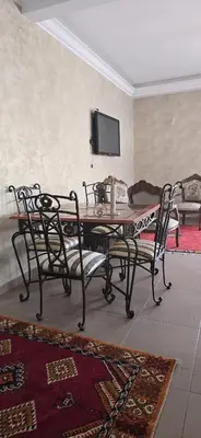 a dining room with a table and chairs and a tv at La corniche in Casablanca