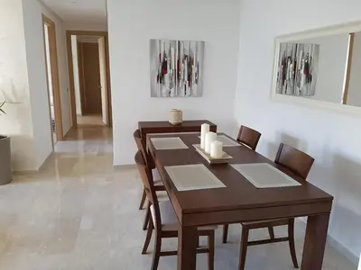 a dining room with a wooden table and chairs at Luxury apartment in Hay Riad, Prestigia, Rabat in Rabat