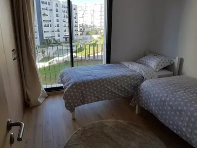 two twin beds in a room with a window at Luxury apartment in Hay Riad, Prestigia, Rabat in Rabat