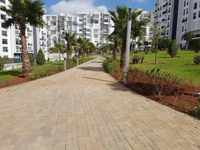 a brick walkway with palm trees and buildings at Luxury apartment in Hay Riad, Prestigia, Rabat in Rabat