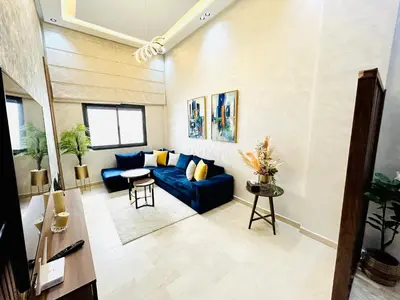 a living room with a blue couch and a table at Casablanca Luxury Studio Apartment Steps to the Beach in Casablanca