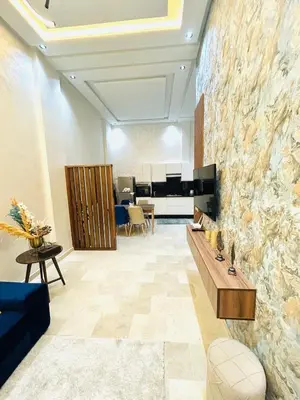 a living room with a large stone wall at Casablanca Luxury Studio Apartment Steps to the Beach in Casablanca