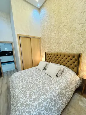 a bedroom with a large bed with two pillows on it at Casablanca Luxury Studio Apartment Steps to the Beach in Casablanca