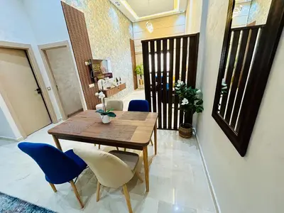 a dining room with a wooden table and blue chairs at Casablanca Luxury Studio Apartment Steps to the Beach in Casablanca