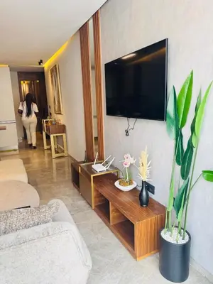 a living room with a couch and a tv on the wall at CYPRessa Loft - Nature and Serenity - Corniche Access in Casablanca