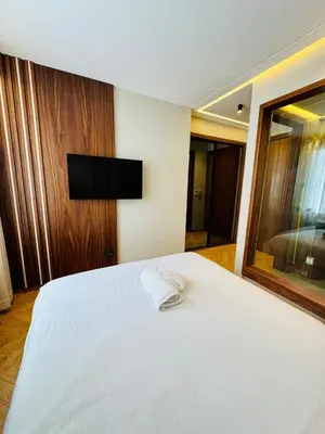 a bedroom with a white bed and a flat screen tv at CYPRessa Loft - Nature and Serenity - Corniche Access in Casablanca