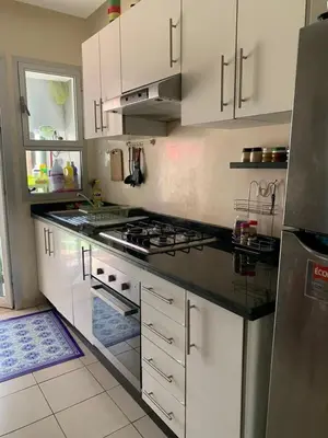a kitchen with white cabinets and a stove top oven at Bahia Golf Beach Odyssée Appt Familial Bord De Mer in Bouznika