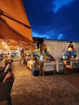 a patio with couches and chairs and a restaurant at Bahia Golf Beach Odyssée Appt Familial Bord De Mer in Bouznika