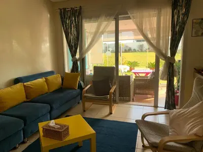 a living room with a couch and a table at Bahia Golf Beach Odyssée Appt Familial Bord De Mer in Bouznika