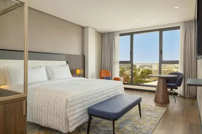 a bedroom with a bed and a large window at Le Meridien Casablanca in Casablanca